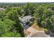 Aerial view of a two-story brick and white home surrounded by lush greenery and mature trees in the neighborhood at 7862 W 84Th Ct, Arvada, CO 80005