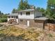 The back of the two-story brick house features a patio area and mature trees at 7862 W 84Th Ct, Arvada, CO 80005