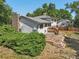 Exterior shot of a two-story home's backyard with mature trees, patio, and chimney at 7862 W 84Th Ct, Arvada, CO 80005