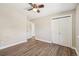 Light-filled bedroom with wood-look floors, ceiling fan, and closets with white bi-fold doors at 7862 W 84Th Ct, Arvada, CO 80005