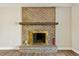 Close up of cozy brick fireplace with wood mantle and decor at 7862 W 84Th Ct, Arvada, CO 80005