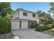 Two-story brick and white home featuring an attached garage, a well-manicured lawn, and mature trees at 7862 W 84Th Ct, Arvada, CO 80005