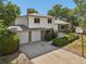 Two-story brick and white home featuring an attached garage, a well-manicured lawn, and mature trees at 7862 W 84Th Ct, Arvada, CO 80005