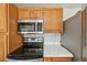 This kitchen shows stainless appliances and wood cabinets with ample countertop space at 7862 W 84Th Ct, Arvada, CO 80005