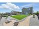 Backyard featuring artificial grass, stone landscaping, and a gravel seating area at 27125 E Bayaud Ave, Aurora, CO 80018