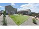 Backyard featuring artificial grass, stone landscaping, a gravel seating area, and a patio at 27125 E Bayaud Ave, Aurora, CO 80018