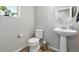 Charming powder room with pedestal sink, round mirror, and updated fixtures at 27125 E Bayaud Ave, Aurora, CO 80018