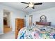 Bright bedroom with a ceiling fan, wood furniture, and view to closet at 27125 E Bayaud Ave, Aurora, CO 80018