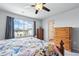 Bedroom with ceiling fan and view of the neighborhood through the window at 27125 E Bayaud Ave, Aurora, CO 80018
