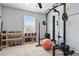 This home gym features weights, a power rack, and natural light from a window at 27125 E Bayaud Ave, Aurora, CO 80018