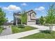 Attractive two-story home showcasing a lush green lawn, young trees, and neutral color palette at 27125 E Bayaud Ave, Aurora, CO 80018
