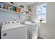 Bright laundry room with modern washer and dryer, shelving, and natural light at 27125 E Bayaud Ave, Aurora, CO 80018