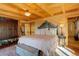 Cozy main bedroom features wood beam ceiling, plush bedding, and ample closet space at 11450 Marks Dr, Conifer, CO 80433