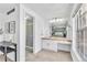 Bright bathroom view including the sink/vanity space, the door to the toilet/shower, and a view into the main bedroom at 7707 S Curtice Way # D, Littleton, CO 80120