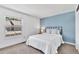 Cozy bedroom with a queen bed and blue accent wall, illuminated by a window at 7707 S Curtice Way # D, Littleton, CO 80120