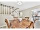 Dining area featuring a rustic wooden table, stylish chairs, and a staircase leading to the upper level at 7707 S Curtice Way # D, Littleton, CO 80120