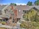 Aerial view of townhome, with brick chimney, neutral siding and landscaped front yard, walkway to inviting front entrance at 7707 S Curtice Way # D, Littleton, CO 80120