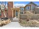 Charming townhome featuring a brick chimney, neutral siding and landscaped front yard and inviting front entrance at 7707 S Curtice Way # D, Littleton, CO 80120