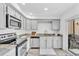 Well-lit kitchen featuring stainless steel appliances, gray cabinets, modern countertops, and access to the backyard at 7707 S Curtice Way # D, Littleton, CO 80120