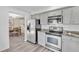 Kitchen featuring stainless steel appliances, grey cabinets, granite countertops, and an adjacent dining area at 7707 S Curtice Way # D, Littleton, CO 80120
