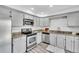 Kitchen featuring stainless steel appliances, granite countertops, grey cabinets, and modern fixtures at 7707 S Curtice Way # D, Littleton, CO 80120