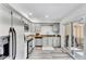 Well-lit kitchen with stainless steel appliances, modern countertops, gray cabinets, and access to the backyard at 7707 S Curtice Way # D, Littleton, CO 80120