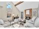 Inviting living room featuring a brick fireplace, wood beam, and large windows allowing plenty of natural light at 7707 S Curtice Way # D, Littleton, CO 80120