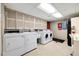 On-site laundry room with machines, overhead storage, and tiled floors for residents at 1045 N Pennsylvania St # 303, Denver, CO 80203