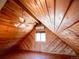 Attic featuring wood paneled walls, window with a view, AC unit, and ceiling fan with lights at 750 Cougar Dr, Boulder, CO 80302