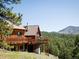 Wood cabin featuring a spacious deck with scenic views of the surrounding forest and mountains at 750 Cougar Dr, Boulder, CO 80302