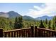 Scenic mountain view from a wooden deck surrounded by lush evergreen trees on a sunny day with a blue sky at 750 Cougar Dr, Boulder, CO 80302