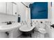 Charming bathroom with a clawfoot tub, vintage sink, and contrasting blue wall behind the toilet at 1356 N Pearl St # 109, Denver, CO 80203