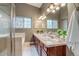 Bathroom featuring double sinks, a vanity with storage, a large mirror, and tiled shower at 3937 Osceola St, Denver, CO 80212