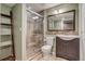 Tiled bathroom featuring a glass shower, modern vanity, toilet, and rustic ladder decor at 3937 Osceola St, Denver, CO 80212