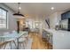 This kitchen features navy blue cabinets, stainless appliances, an island with bar stool seating, and is adjacent to the living room at 3937 Osceola St, Denver, CO 80212