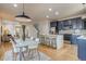 This kitchen features navy blue cabinets, stainless appliances, an island with bar stool seating, and is adjacent to the living room at 3937 Osceola St, Denver, CO 80212