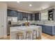 This kitchen is equipped with navy blue cabinets, stainless steel appliances and an island with a white countertop and bar stool seating at 3937 Osceola St, Denver, CO 80212
