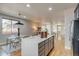 This kitchen features navy blue cabinets, stainless appliances, an island with bar stool seating, and is adjacent to the living room at 3937 Osceola St, Denver, CO 80212
