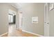 Hallway with a neutral color scheme, hardwood floors, and a view into another room at 2572 S Vine St, Denver, CO 80210