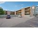 This apartment building is multi-story with stone accents, balconies, and a large parking area for tenants at 250 N Pearl St # 310, Denver, CO 80203