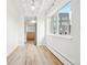 Open living space with hardwood floors, large window, and a view to the kitchen at 250 N Pearl St # 310, Denver, CO 80203