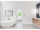 Bright bathroom featuring a soaking tub, modern fixtures, and ensuite access to bedroom at 1466 S Gaylord St, Denver, CO 80210