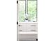 Close up of a white dresser with black modern hardware in a bright room with large windows at 1466 S Gaylord St, Denver, CO 80210