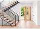 Bright entryway boasting light wood floors, floating stairs with iron railing, and a statement front door at 1466 S Gaylord St, Denver, CO 80210