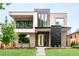 Modern home featuring mixed brick and panel facade with a well-manicured lawn and minimalist landscaping at 1466 S Gaylord St, Denver, CO 80210