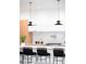 Contemporary kitchen island featuring black stools, white marble countertops, and designer pendant lights at 1466 S Gaylord St, Denver, CO 80210