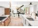 Modern kitchen featuring stainless steel appliances, an island, and an adjacent dining area with staircase at 1466 S Gaylord St, Denver, CO 80210