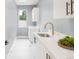 Bright laundry room with white cabinets, gold hardware, and white countertops at 1466 S Gaylord St, Denver, CO 80210