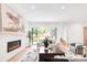 Bright living room with a modern fireplace, hardwood floors and sliding glass doors to the backyard at 1466 S Gaylord St, Denver, CO 80210