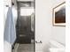 Modern bathroom with a dark tiled walk-in shower, matte black fixtures, and glass door at 1466 S Gaylord St, Denver, CO 80210